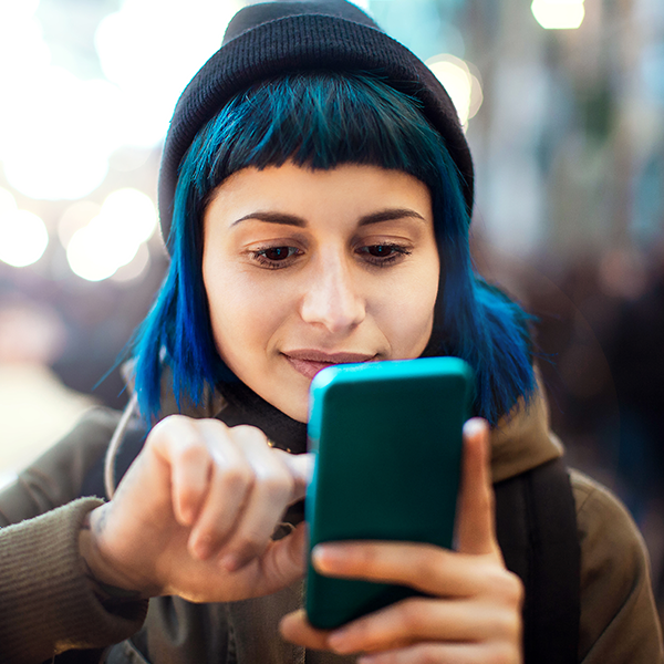 A person looks at their phone as they safety plan regarding their abusive situation.